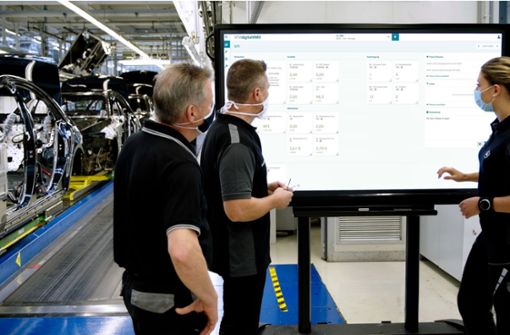 Mitarbeiter blicken auf die Daten, die während des Produktionsprozesses anfallen. Foto: Daimler AG/Mercedes-Benz AG