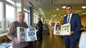 Rolf Deuschle (links) hat in zahlreichen Alben die Geschichte Denkendorfs dokumentiert. Diese hat er jetzt an Bürgermeister Ralf Barth (rechts) übergeben. Foto: /Ulrike Rapp-Hirrlinger