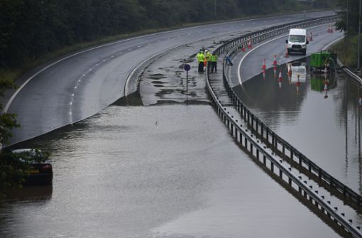 Land unter: Polizisten sperren die überschwemmte A 555  nahe Manchester Foto: dpa