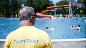 Ein Bademeister steht im Herzogenriedbad vor einem Schwimmbecken mit Wasserrutsche (Archivbild). Foto: dpa/Uwe Anspach