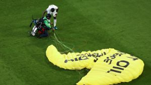Nationalspieler Antonio Rüdiger erkundigt sich nach dem Befinden des Greenpeace-Aktivisten. Foto: dpa/Christian Charisius