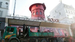 Arbeiter sichern den Bereich vor dem Kabarett, nachdem die Flügel des Windrads des Moulin Rouge in der Nacht abgestürzt sind. Foto: Geoffroy Van Der Hasselt/AFP/dpa