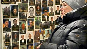 Die Lehrerin Marija Mezentseva (62) steht vor einer Collage von gefallenen ukrainischen Soldaten in einer Kirche in Lwiw, von denen sie einige selbst unterrichtete Foto: red/Feyder