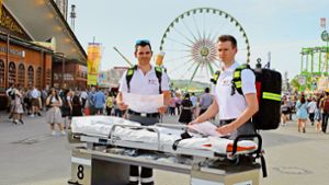 Mit der Rolltrage auf dem Cannstatter Wasen: Alexander Jahn und Maximilian Niemann (rechts) sind ehrenamtlich beim Stuttgarter Frühlingsfest im Einsatz. Foto: Sebastian Steegmüller