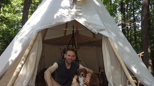 Marc Freukes sitzt mit seinem Hund Rala vor seinem Tipi im Odenwald und genießt die Ruhe  abseits Foto: dpa