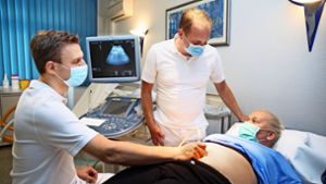 Stefan P. Renner macht eine Ultraschalluntersuchung des Beckenraumes von Ivonne van der Lee, während   Michael Burkhardt mit der Patientin spricht. Foto: Horst Rudel