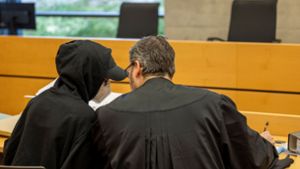 Eine der beiden Angeklagten (l) unterhält sich mit ihrem Rechtsanwalt im Sitzungssaal im Landgericht. Foto: Heiko Becker/dpa