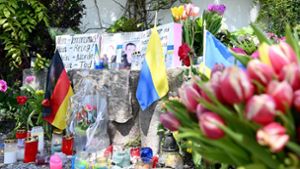 Neben dem Einkaufszentrums an dem die zwei Männer aus der Ukraine getötet worden sind, haben Menschen Blumen und Plakate niedergelegt. Foto: dpa/Angelika Warmuth