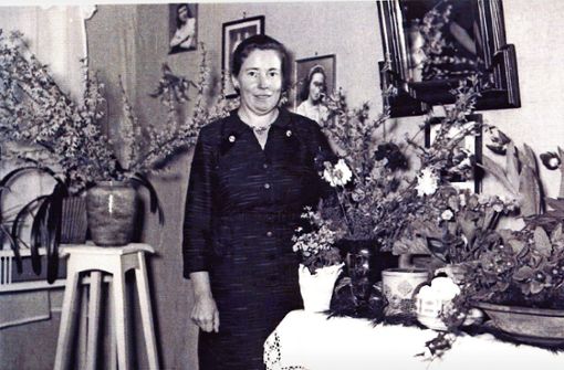 Anna Müller 1957 nach ihrer Rückkehr in ihrem Wohnzimmer. Die vielen Blumen gab es wohl zum Empfang. Foto: /Ulrike Rapp-Hirrlinger