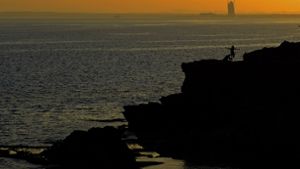 Zypern, Ayia Napa: Touristen genießen den Sonnenuntergang bei den Meereshöhlen im südlichen Küstenort Ayia Napa im Südosten der Mittelmeerinsel Zypern. Foto: Tom Jennings/AP/dpa/Tom Jennings