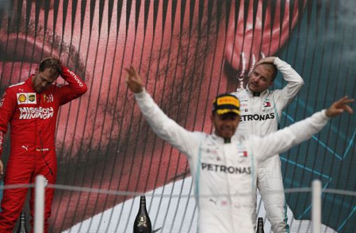 Während Lewis Hamilton vorne feiert, kann sich Sebastian Vettel nur den Kopf kratzen. Foto: AP/Rebecca Blackwell