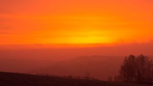 Wegen des Saharastaub in der Luft ist der Himmel bei Sonnenaufgang rötlich gefärbt –  wie hier im sächsischen  Bärenstein. Foto: Foto: promovie/dpa/Oliver Kaufmann