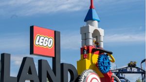 Neben dem Logo am Eingang zum Legoland ist eine Achterbahn zu sehen. Foto: dpa/Stefan Puchner