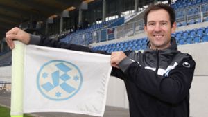 Matthias Becher hält die Kickers-Fahne hoch  – seit 2020 arbeitet der ehemalige Hockeyspieler und -trainer als Geschäftsführer bei den Blauen. Foto: Baumann/Hansjürgen Britsch
