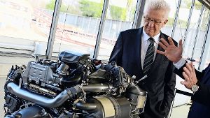 Ministerpräsident Winfried Kretschmann mit einem Dieselmotor bei einer Daimler-Werksbesichtigung. Foto: dpa