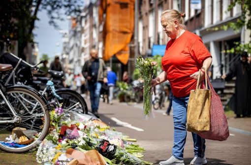 Eine Passantin in Amsterdam legt Blumen  für Peter R. de Vries nieder. Foto: AFP/Koen Van Weel