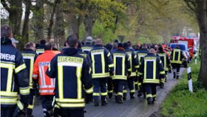 Feuerwehrleute laufen auf einer Straße bei Bremervörde. Von einem vermissten sechs Jahre alten Jungen aus dem niedersächsischen Bremervörde fehlt noch immer jede Spur. Foto: dpa/Markus Hibbeler
