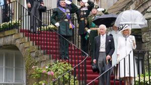 Unterm transparenten Regenschirm: König Charles III. und Königin Camilla auf den Stufen von Holyrood Palace in Edinburgh. Foto: AFP/JONATHAN BRADY