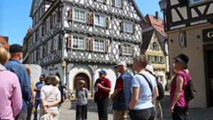 Stadtführer Bernhard Schwegler (Mitte) kennt sich mit historischen Fachwerkbauten und  Schmuckelementen aus. Foto: Eva Herschmann