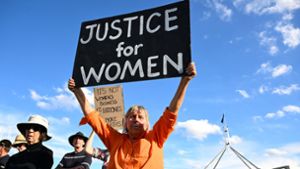 In Canberra fordert eine Frau Justice for Women (Gerechtigkeit für Frauen). Foto: Lukas Coch/AAP/dpa