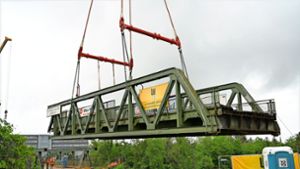 Riesenkran lässt Stahlbrücke schweben