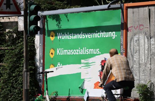 Ein beschädigtes Plakat mit den Schriftzügen „Wohlstandsvernichtung“ und „Klimasozialismus“ hängt am Straßenrand. Foto: dpa/Oliver Berg