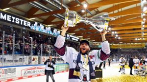 Berlins Yannick Veilleux jubelt nach dem Gewinn der deutschen Eishockey-Meisterschaft mit dem Pokal. Foto: Carmen Jaspersen/dpa