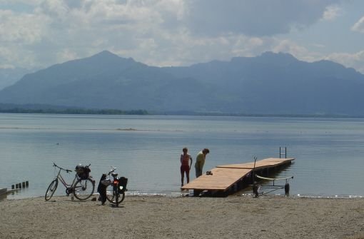 Verdiente Pause: Nach einer Radtour rund um den Chiemsee lohnt sich ein Bad mit Blick auf die Chiemgauer Berge. Foto: Erne
