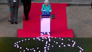 Die Queen berührte als Startschuss einen kleinen Globus. Foto: AFP/TOBY MELVILLE