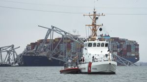 Ein Boot der Küstenwache patrouilliert im Hafen von Baltimore vor dem Unglücksschiff, das die Brücke zerstört hat. Foto: dpa/Steve Helber
