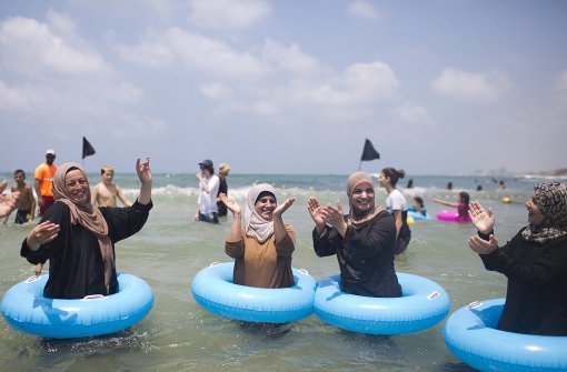 Burkini-Trägerinnen tanzen und singen am Strand von Tel Aviv. Foto: EPA