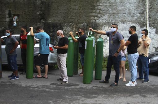Familienmitglieder von Covid-19-Patienten stehen an, um Sauerstoffflaschen auffüllen zu lassen. In Manaus herrscht derzeit akuter Mangel von Sauerstoff für Kranke. Foto: dpa/Edmar Barros