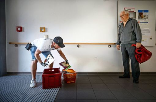 Auslieferung mit Sicherheitsabstand: Der Eismann Stefan Ruoff packt die bestellte Ware in den Korb seines Kunden. Foto: /Gottfried Stoppel