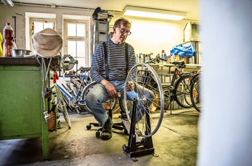 Christoph Preussler überprüft, ob die Felge verzogen ist.  Wenn alles passt, wird sie in ein neues altes Rad eingesetzt. Foto: Lichtgut/Julian Rettig