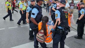 Eine Aktivistin der „Letzten Generation“ wird am Stuttgarter Hauptbahnhof von Polizisten von der Straße getragen. Foto: Andreas Rosar