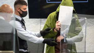 Der Täter verdeckt am Landgericht Stuttgart sein Gesicht. Foto: dpa//Sebastian Gollnow