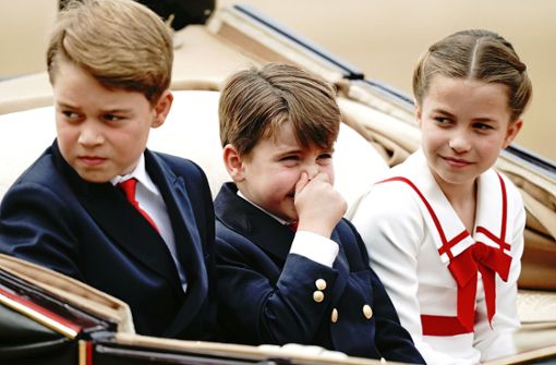 Prinz Louis hält sich die Nase zu, Prinzessin Charlotte und Prinz George schauen sich das Spektakel von „Trooping the Colour“ an. Foto: dpa/Aaron Chown