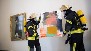 Feuerwehrleute tragen ein Kunstwerk aus dem Altbau der Staatsgalerie Stuttgart. Foto: dpa/Tom Weller