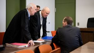 Der frühere BND-Mitarbeiter unterhält sich im Oberlandesgericht in München vor Prozessbeginn mit seinen Anwälten Walter Lechner (links) und Klaus Schroth. Foto: dpa