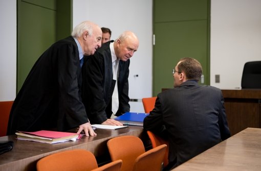 Der frühere BND-Mitarbeiter unterhält sich im Oberlandesgericht in München vor Prozessbeginn mit seinen Anwälten Walter Lechner (links) und Klaus Schroth. Foto: dpa