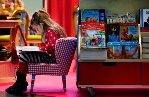 Versunken in eine andere Welt: Ein Mädchen ist auf der Leipziger Buchmesse in die Lektüre vertieft. Unsere Bildergalerie bietet 20 Anregungen für gute Kinder- und Jugendbücher. Foto: dpa