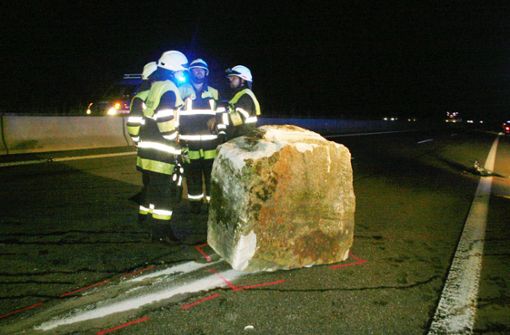 Feuerwehrleute neben dem drei Tonnen schweren Steinquader auf der  A 81 Foto: kamera24