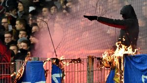 Die Frankfurter Fans brennen Darmstädter Fahnen und Schals ab. Foto: dpa