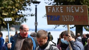 „Fake News – Trump Testet Positive“, steht auf einem Schild. Einige Skeptiker bezweifeln, dass der US-Präsident sich wirklich mit dem Coronavirus infiziert hat. Foto: AFP/SEBASTIEN BOZON