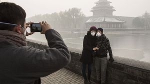 Bitte recht freundlich, auch wenn man von der Verbotenen Stadt im Hintergrund herzlich wenig erkennen kann. Die Luftverschmutzung in Peking hat unglaubliche Höchstwerte erreicht. Foto: Getty Images