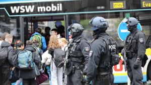 Polizisten führen Schüler in Wuppertal aus dem Gebäude in einen Evakuierungsbus. Foto: Sascha Thelen/dpa