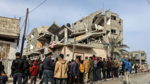 Menschen versammeln sich nach einem israelischen Luftangriff in Rafah um das zerstörte Haus einer Familie. Foto: Abed Rahim Khatib/dpa