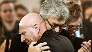 Sebastião Salgado (vorne) und sein Laudator Wim Wenders liegen einander in der Frankfurter Paulskirche in den Armen. Foto: AFP/Daniel Roland