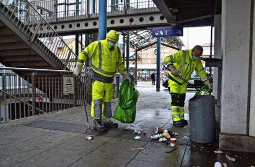 Thomas Metzger (rechts) und Günther Blank sammeln auf dem Bahnhofsvorplatz ein, was über das Wochenende weggeworfen wurde. Foto: Dominik Florian