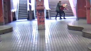 Ein junger Mann greift an der U-Bahnhaltestelle Viehofer Platz hinterrücks eine junge Frau an. Mit dem Überwachungsvideo aus dem das Bildschirmfoto stammt, sucht die Polizei nach zwei Tätern, die die junge Frau am 13. April in Essen mit einer Flasche angegriffen haben. Foto: dpa/Polizei Essen